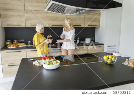 Two adult women talking with coffee at home 58703811