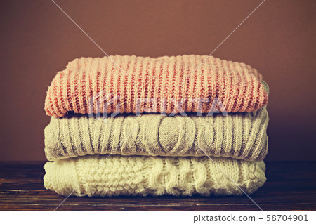 Pile of knitted sweaters of different colors and Pile of knitted sweaters of different colors and 58704901