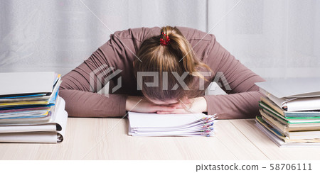 Young tired woman freelancer at home office desk 58706111