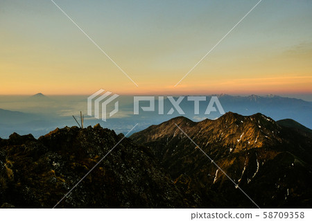 Spring Yatsugatake mountain climbing: Dawn at the summit of Mt. Akadake (Fuji, Southern Alps distant view) 58709358