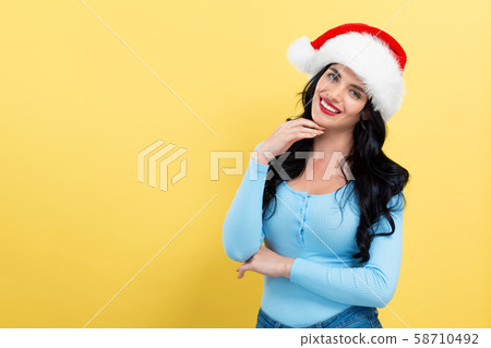 Young woman with Santa hat thoughtful pose 58710492