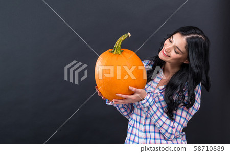 Young woman holding a pumpkin Young woman holding a pumpkin 58710889