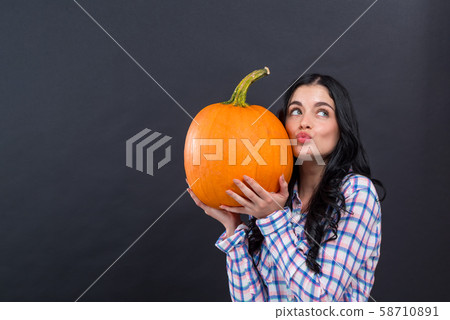 Young woman holding a pumpkin 58710891