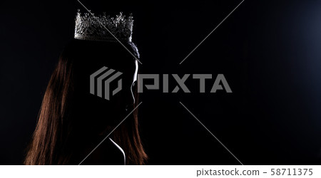 Portrait of Miss Pageant Beauty Contest in sequin Evening Ball Gown long dress with sparkle light Diamond Crown, silhouette low key exposure with curtain, studio lighting dark background dramatic 58711375