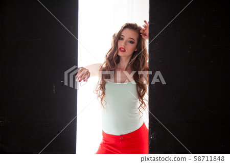 Portrait of a beautiful woman with long hair sitting on the floor Portrait of a beautiful woman with long hair sitting on the floor 58711848
