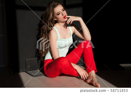 Portrait of a beautiful woman with long hair sitting on the floor 58711853