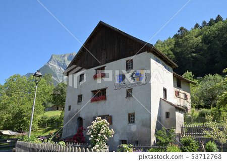 Heididorf village hall with the flag of Graubünden and the basic municipality chapter 58712768
