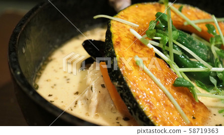Close-up images of yellow color soup curry with chicken, pork and vegetable in bowl which famous traditional food menu and only found in Hokkaido Sapporo district of Japan Close-up images of yellow color soup curry with chicken, pork and vegetable in bowl which famous traditional food menu and only found in Hokkaido Sapporo district of Japan 58719363
