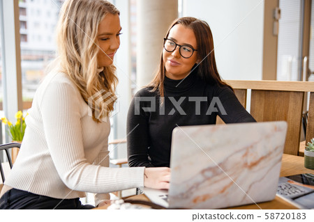 Close-up of Smiling Young Somen Discussing Over Publication In Cafe Close-up of Smiling Young Somen Discussing Over Publication In Cafe 58720183