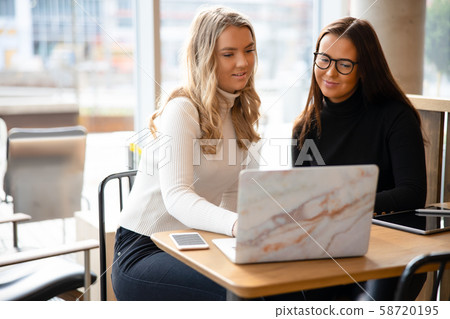 Smiling Bloggers Networking Online On Laptop At Table 58720195