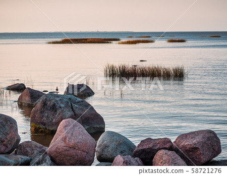 Red granite boulders on the lake. 58721276