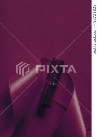 Luxury lipstick and silk ribbon on plum holiday Luxury lipstick and silk ribbon on plum holiday 58721828