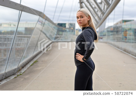 Fit Woman in Black Workout Wear Standing At Modern Bridge In City 58722074