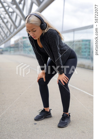 Tired Woman Resting With Hands On Knees After Running Workout 58722077