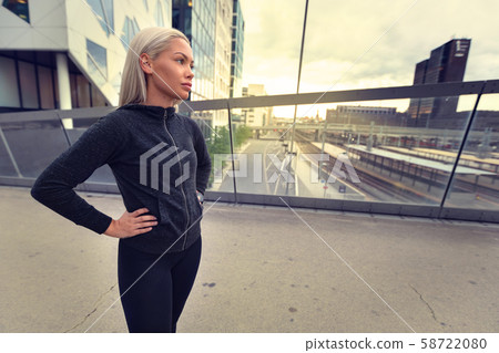 Female Jogger Resting With Hands On Hips After Workout at Sunset Female Jogger Resting With Hands On Hips After Workout at Sunset 58722080