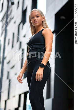 Beautiful Fitness Woman Standing Against Futuristic Modern Building In City 58722233