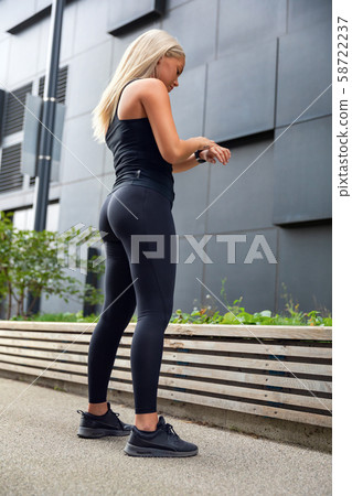 Urban woman using fitness smart watch device before running 58722237