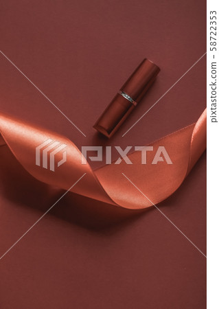 Luxury lipstick and silk ribbon on bronze holiday Luxury lipstick and silk ribbon on bronze holiday 58722353