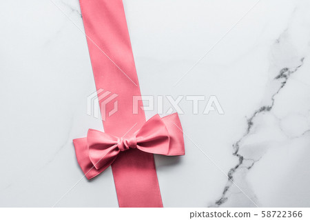 Coral silk ribbon and bow on marble background, Coral silk ribbon and bow on marble background, 58722366