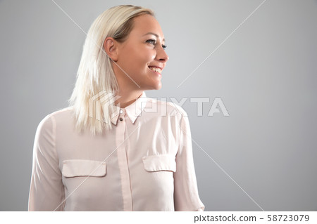 Happy and natural female blonde model smiling in pink shirt 58723079