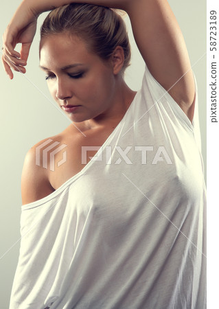 Studio portrait of beautiful woman with blonde hair and white t-shirt Studio portrait of beautiful woman with blonde hair and white t-shirt 58723189