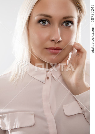 Beautiful female blonde model in shirt holding her hair Beautiful female blonde model in shirt holding her hair 58723245