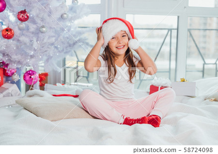 Sweet shot of small princess, sitting on a bed and smiling lovely. 58724098