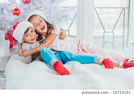 Two young happy cute laughing children, boy and girl, brother and sister having fun in the morning 58724101