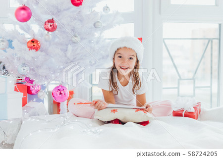Expressive little girs is showing with gestures and face expression that mailing with santa is Expressive little girs is showing with gestures and face expression that mailing with santa is 58724205
