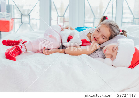 Two exhausted kids are sleeping, cuddling sweetly after new year party. 58724418
