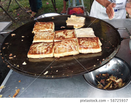 Malaysian street food called Murtabak. In it there is a mixture of meat, eggs and onions. Eaten with a special gravy. 58725937