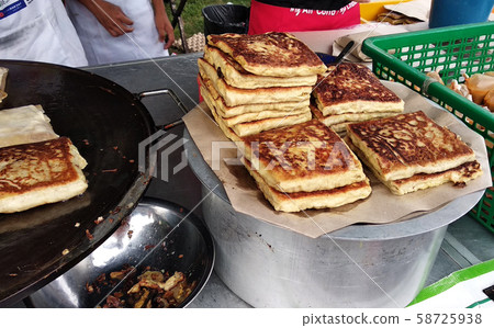 Malaysian street food called Murtabak. In it there is a mixture of meat, eggs and onions. Eaten with a special gravy. 58725938