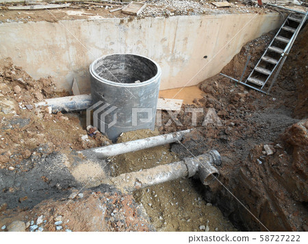 Underground drainage manhole under construction by construction workers at the construction site. The manhole design based on infrastructure engineer design. Underground drainage manhole under construction by construction workers at the construction site. The manhole design based on infrastructure engineer design. 58727222