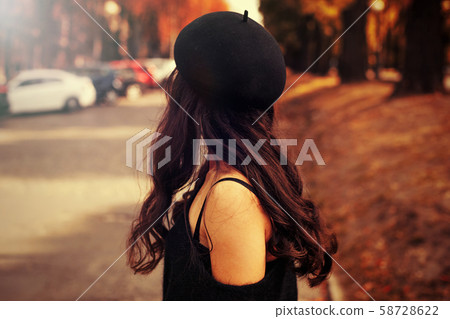 woman in black hat walking on the street 58728622