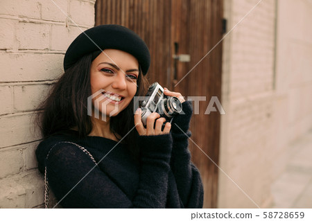 woman holding retro camera and taking picture woman holding retro camera and taking picture 58728659