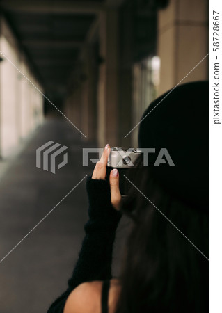 woman holding retro camera and taking picture woman holding retro camera and taking picture 58728667