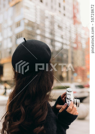 woman holding retro camera and taking picture woman holding retro camera and taking picture 58728672