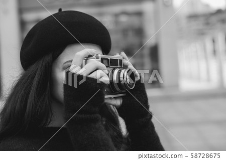 woman holding retro camera and taking picture woman holding retro camera and taking picture 58728675