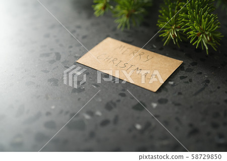 Fresh green spruce twig with brown paper card with happy merry christmas greeting 58729850