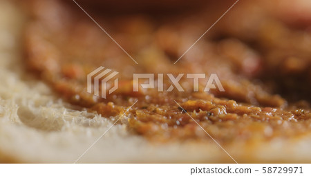 Extreme closeup of ciabatta slice with red pesto 58729971