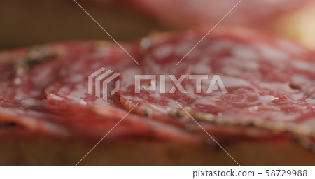 Extreme closeup laying salami slices on ciabatta Extreme closeup laying salami slices on ciabatta 58729988