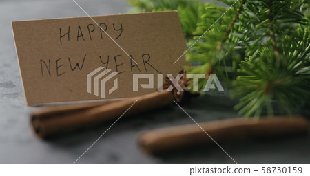 spruce twig with happy new year card on terrazzo countertop with natural decorations spruce twig with happy new year card on terrazzo countertop with natural decorations 58730159