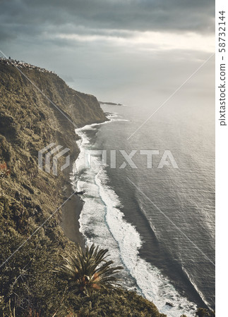 Volcanic beach seen from a cliff at sunset. 58732144