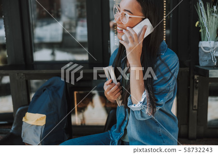 Happy Asian lady in glasses holding smartphone 58732243