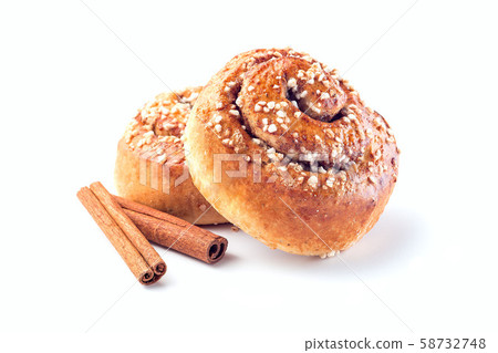 Two cinnamon buns and cinnamon sticks isolated Two cinnamon buns and cinnamon sticks isolated 58732748