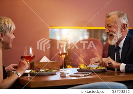 Mature couple enjoy meal at restaurant Mature couple enjoy meal at restaurant 58733255