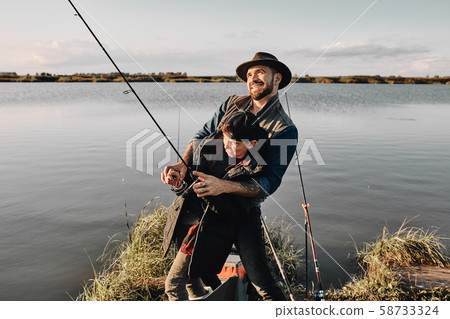 Father and son fishing together on sunny day Father and son fishing together on sunny day 58733324