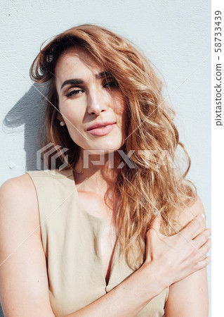 Portrait of a beautiful fashionable woman in a beige dress on a walk Portrait of a beautiful fashionable woman in a beige dress on a walk 58733439