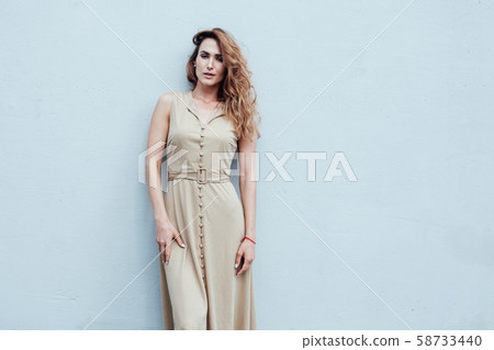 Portrait of a beautiful fashionable woman in a beige dress on a walk 58733440