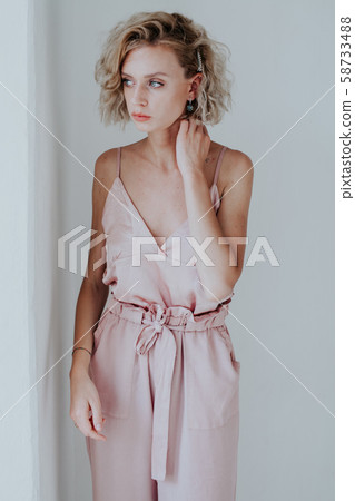 Portrait of a beautiful fashionable woman in a pink jumpsuit Portrait of a beautiful fashionable woman in a pink jumpsuit 58733488
